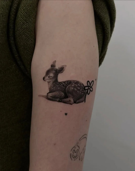 Small Black and Grey Deer with Flower Tattoo on Women Arm by @diananah.ink