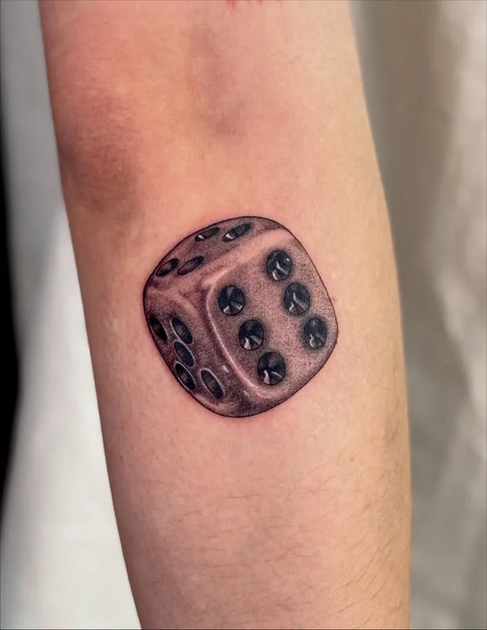 Small Black and Grey Dice Tattoo on Women Arm by @mcqhtattoo