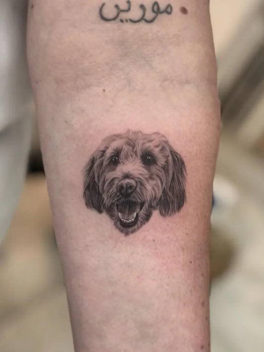 Small Black and Grey Dog Portrait Tattoo on Men Arm by @lauramarshtattoo
