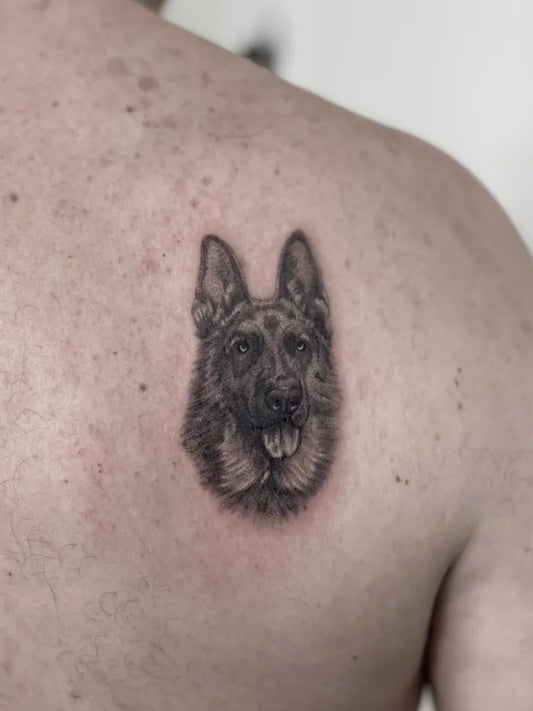Small Black and Grey Dog Portrait Tattoo on Men Shoulder by @mjcampostattoo
