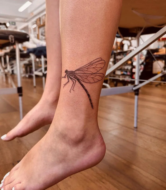 Small Black and Grey Dragonfly Spiritual Tattoo on Women Ankle by @sarahpeteh