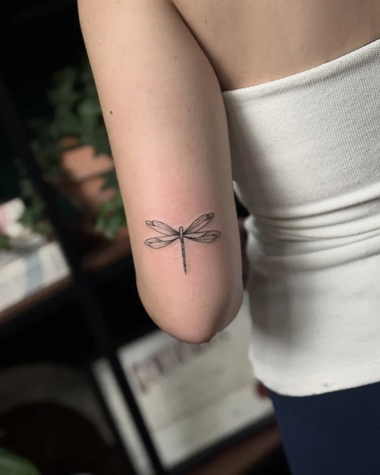 Small Black and Grey Dragonfly on Women Arm Tattoo by @paulo_borrega