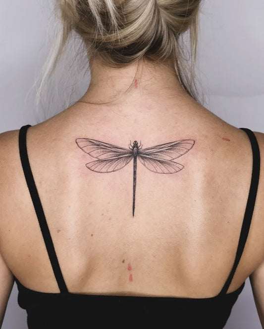 Small Black and Grey Dragonfly on Women Back Tattoo by @sinntraegertattoos