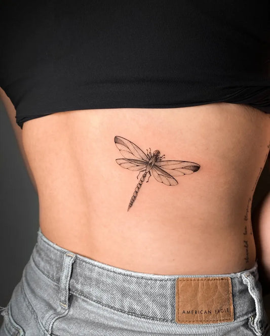 Small Black and Grey Dragonfly on Women Back Tattoo by @tahinos.tattoo