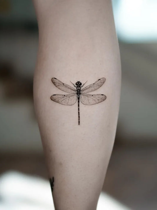 Small Black and Grey Dragonfly on Women Leg Tattoo by @hausoftattoo