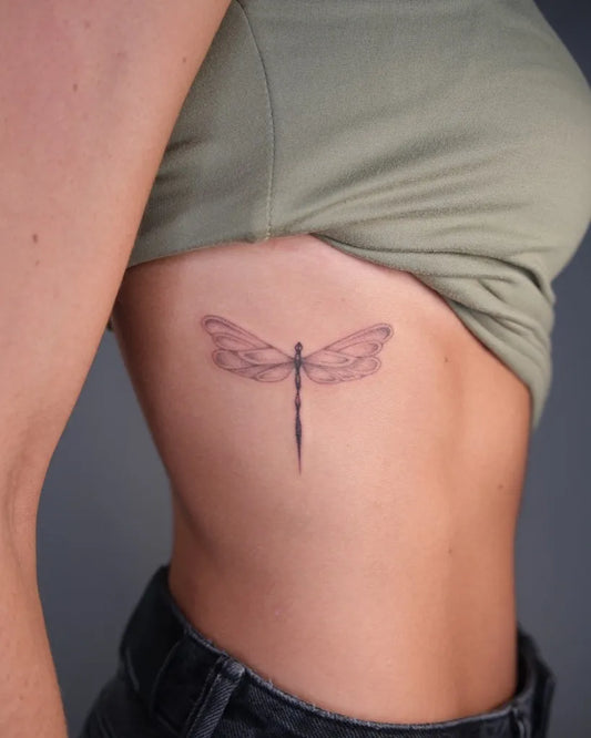Small Black and Grey Dragonfly on Women Ribs Tattoo by @____toledo