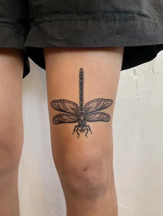 Small Black and Grey Dragonfly on Women Thigh Tattoo by @hannah_tatz