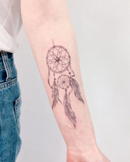 Small Black and Grey Dream Catcher Tattoo on Women Arm by @tattooist_j.l