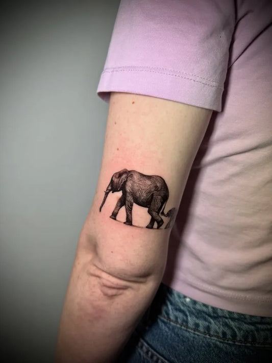 Small Black and Grey Elephant Tattoo on Women Arm by @palomabarrostattoos
