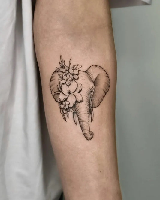 Small Black and Grey Elephant with Flowers Tattoo on Women Arm by @gcimarmc