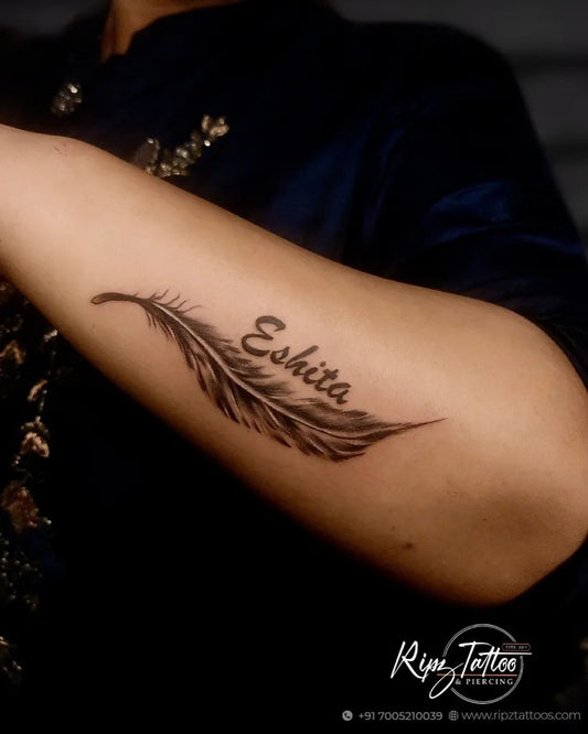 Small Black and Grey Feather Name Tattoo on Women Arm by @ripztattoo