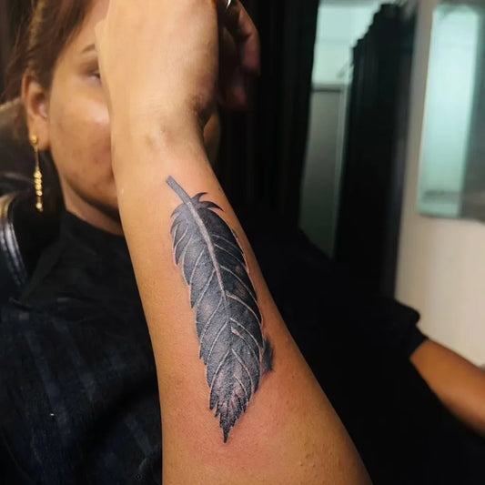 Small Black and Grey Feather Tattoo on Women Arm by @_vishakha__studio_