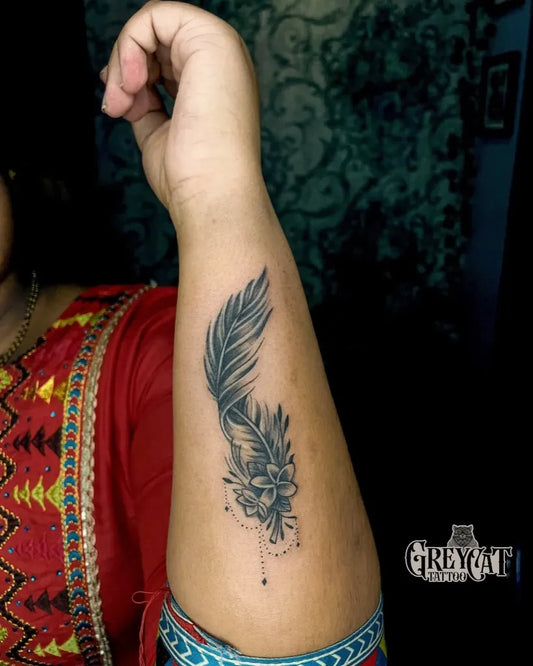 Small Black and Grey Feather and Flower Tattoo on Women Arm by @grey_cat_tattoo_manglore