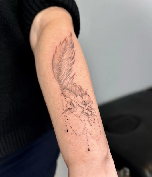 Small Black and Grey Feather and Flower Tattoo on Women Forearm by @dziaaramse