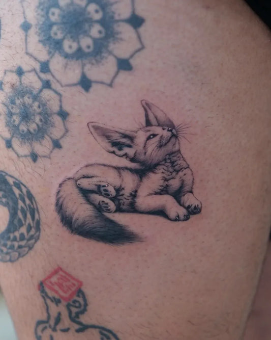 Small Black and Grey Fennec Fox Tattoo on Women Thigh by @inkbytegan