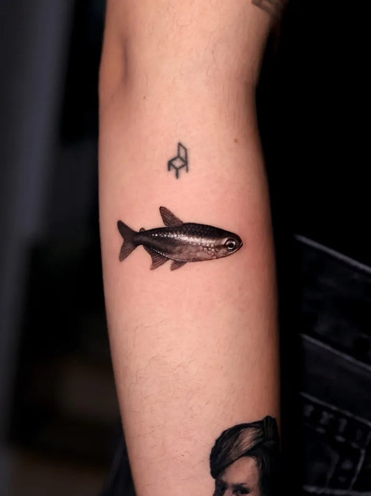 Small Black and Grey Fish Tattoo on Women Arm by @karla.guard