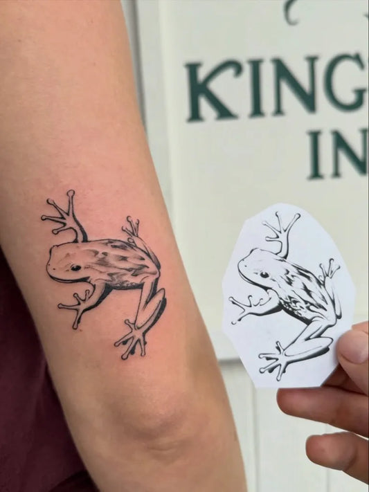 Small Black and Grey Frog Tattoo on Women Arm by @kingtideink