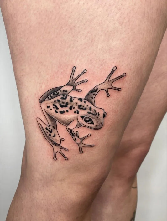 Small Black and Grey Frog Tattoo on Women Thigh by @laneedrak.tattoo