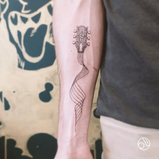 Small Black and Grey Guitar Headstock with Swirling Neck Men Arm by @monsieurolitattoo