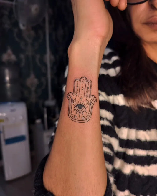 Small Black and Grey Hamsa with Evil Eye on Women Wrist Tattoo by @the_tattoomachine