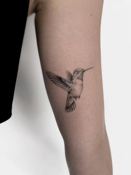 Small Black and Grey Hummingbird on Women Arm Tattoo by @blackbird.at