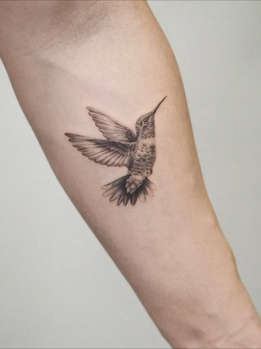 Small Black and Grey Hummingbird on Women Arm Tattoo by @rebustattoo_