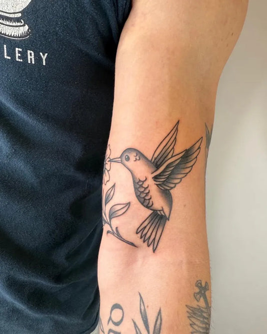 Small Black and Grey Hummingbird with Flowers on Men Arm Tattoo by @rickyttattoo