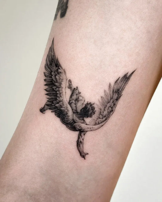 Small Black and Grey Icarus with Wings and Dragon on Women Arm Tattoo by @tattooist_ro