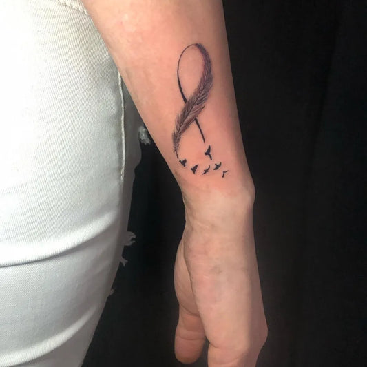 Small Black and Grey Infinity Feather and Birds Tattoo on Women Wrist by @pebz_ink_dubaitattoo