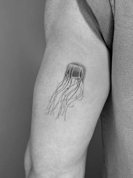 Small Black and Grey Jellyfish Tattoo on Men Upper Arm by @adamclaridge_