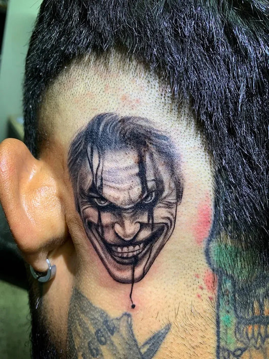 Small Black and Grey Joker Face on Men Head Tattoo by @alejandrogarcia_tattooartist