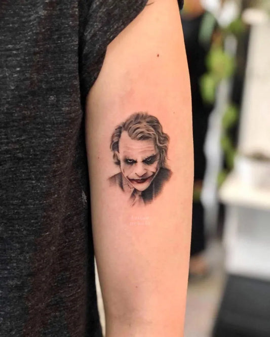 Small Black and Grey Joker Portrait on Women Arm Tattoo by @tattoonebula.art