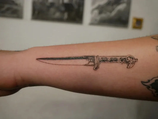 Small Black and Grey Knife Tattoo on Men Forearm by @rudrainktattoo