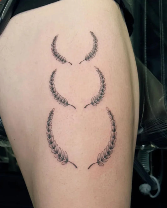 Small Black and Grey Laurel Wreaths Tattoo on Women Thigh by @urvanitogabiana