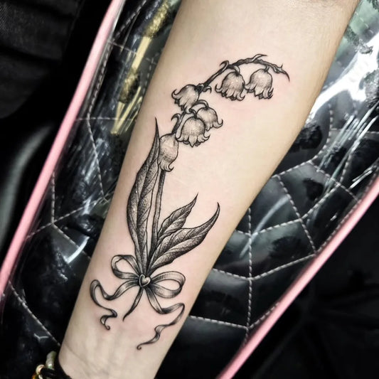 Small Black and Grey Lily of the Valley with Bow on Women Arm Tattoo by @izzyxtattoos