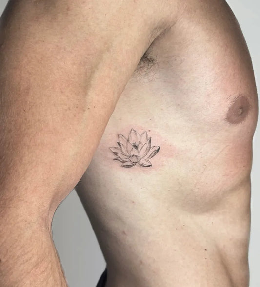 Small Black and Grey Lotus Flower on Men Ribcage Tattoo by @emedepe.tattoo
