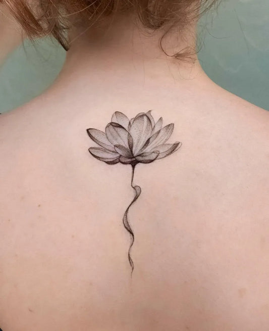 Small Black and Grey Lotus Flower on Women Back Tattoo by @elvis_pachamamatattoo