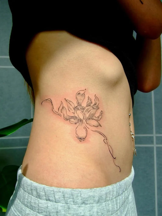 Small Black and Grey Lotus Flower on Women Side Tattoo by @leekaren.tatt