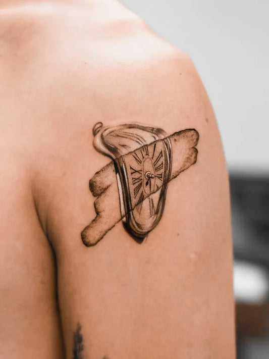 Small Black and Grey Melting Clock Tattoo on Men Shoulder by @oottatjac