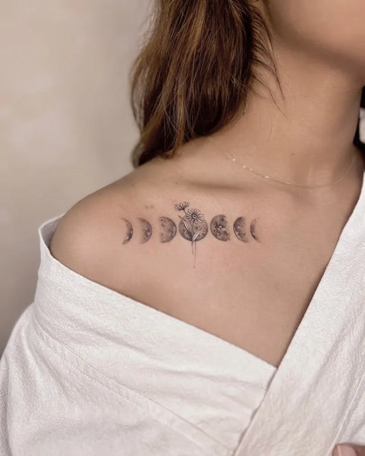 Small Black and Grey Moon Phases Daisy Tattoo on Women Shoulder by @dudutattooist