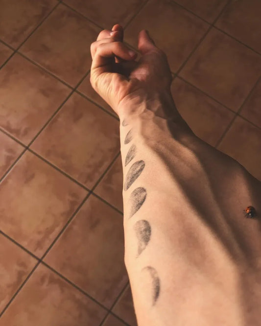 Small Black and Grey Moon Phases Tattoo on Men Wrist by @_adeva._