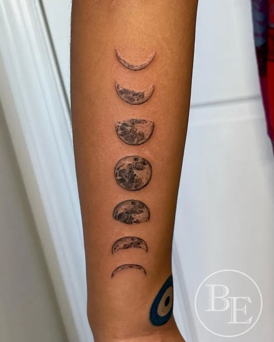 Small Black and Grey Moon Phases Tattoo on Women Arm by @brenna.eagan