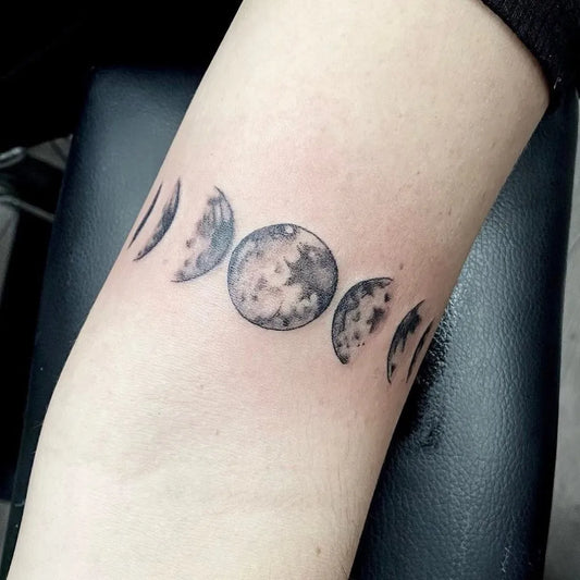 Small Black and Grey Moon Phases Tattoo on Women Arm by @illustratedmantattoo