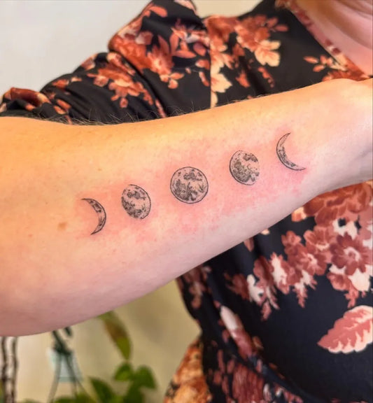 Small Black and Grey Moon Phases Tattoo on Women Forearm by @rachel.josephine.tattoo