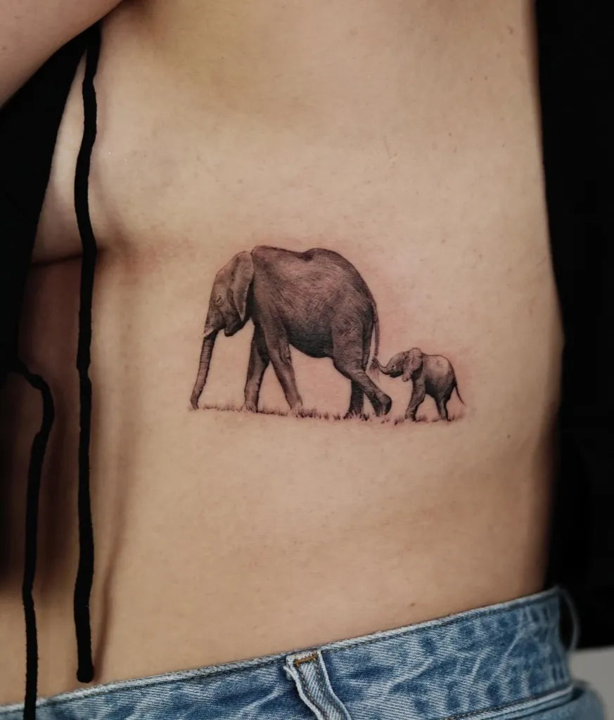 Small Black and Grey Mother and Baby Elephant Tattoo on Women Rib by @zon_tattoo