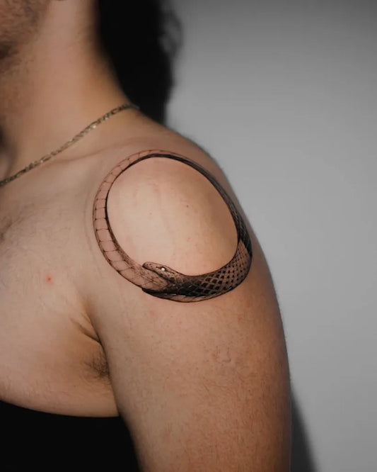 Small Black and Grey Ouroboros Tattoo on Men Shoulder by @zaeno.tattoo