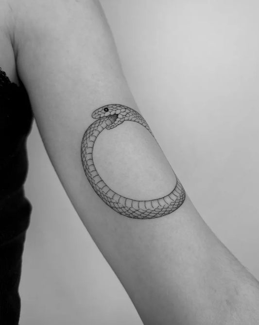 Small Black and Grey Ouroboros Tattoo on Women Arm by @_tiffanynguyen