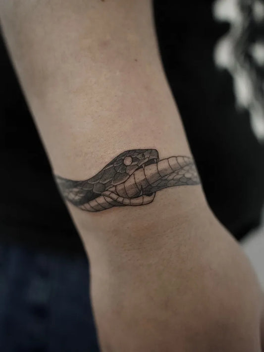 Small Black and Grey Ouroboros Tattoo on Women Wrist by @extrahottattoo