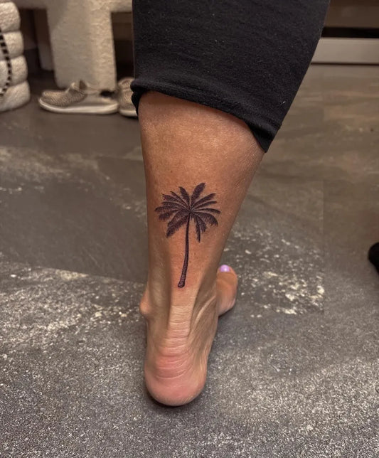 Small Black and Grey Palm Tree Tattoo on Women Ankle by @briegelinkstudio