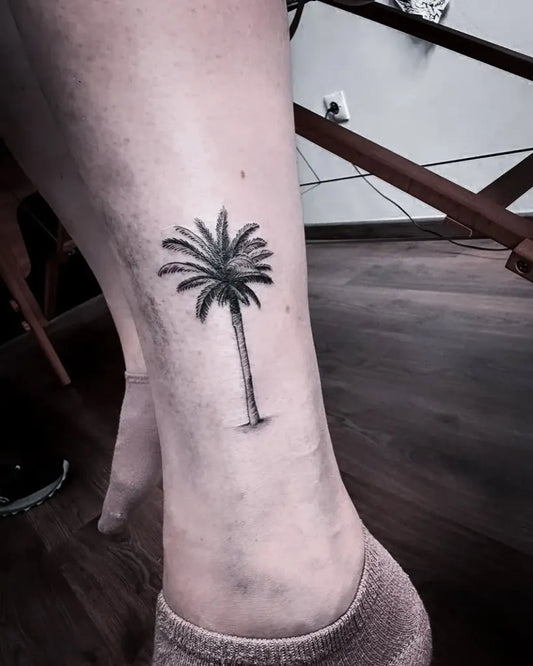 Small Black and Grey Palm Tree Tattoo on Women Leg by @tattoostudiomorocco